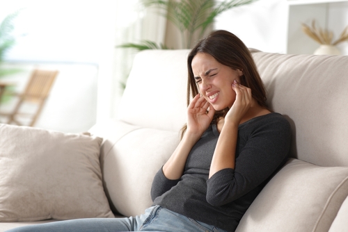 A woman holding her jaw in pain